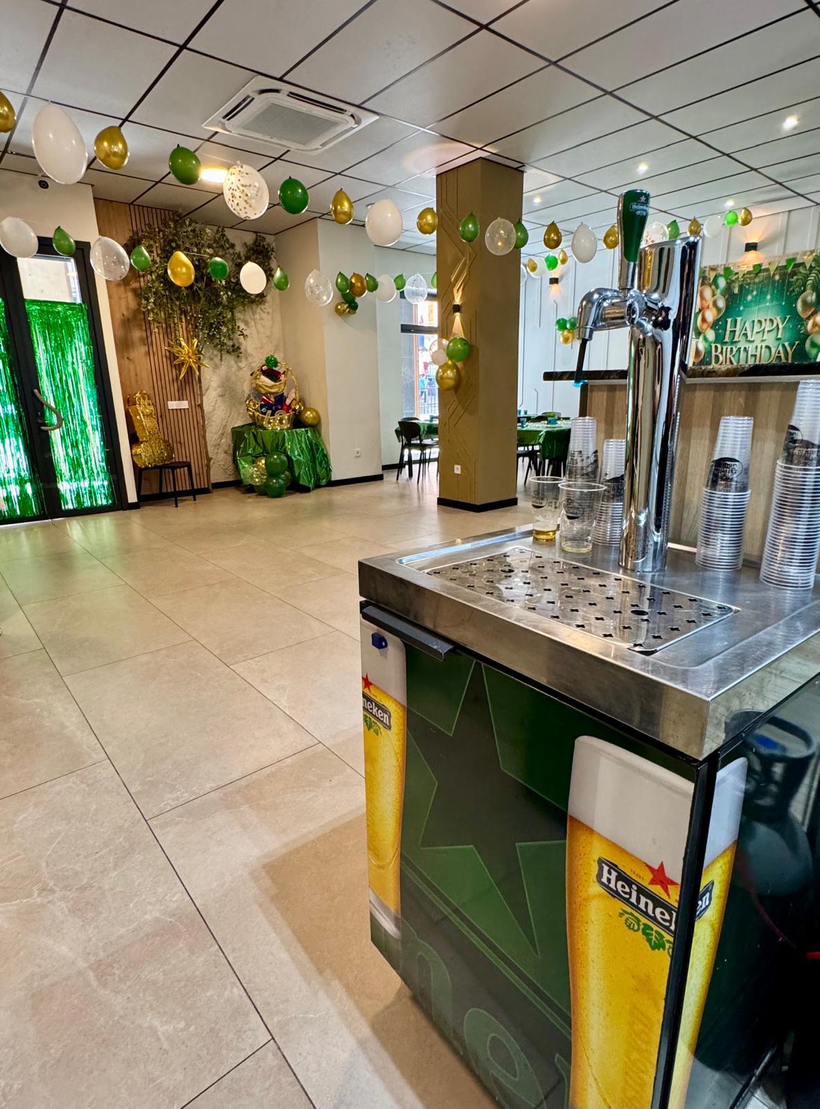 Sala en Alicante preparada para fiestas privadas, decorada con globos y con un grifo de cerveza Heineken. ¡Lista para que empiece la fiesta!